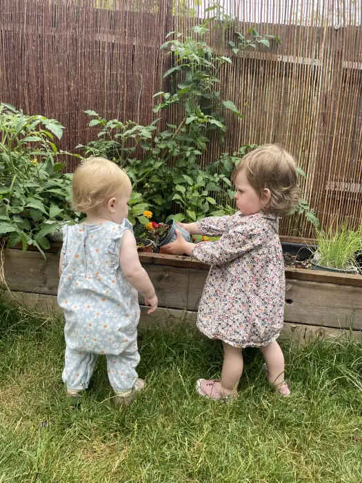 Two children gardening together at a raised bed