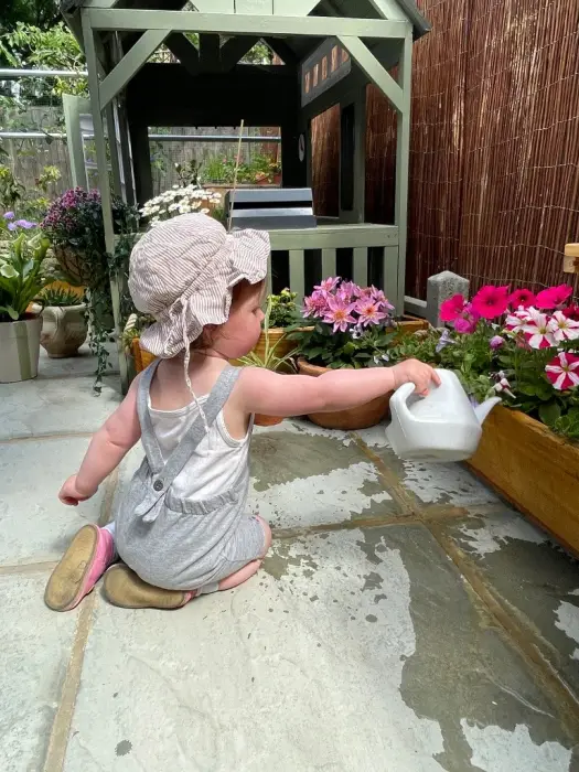 A child watering flowers in the garden